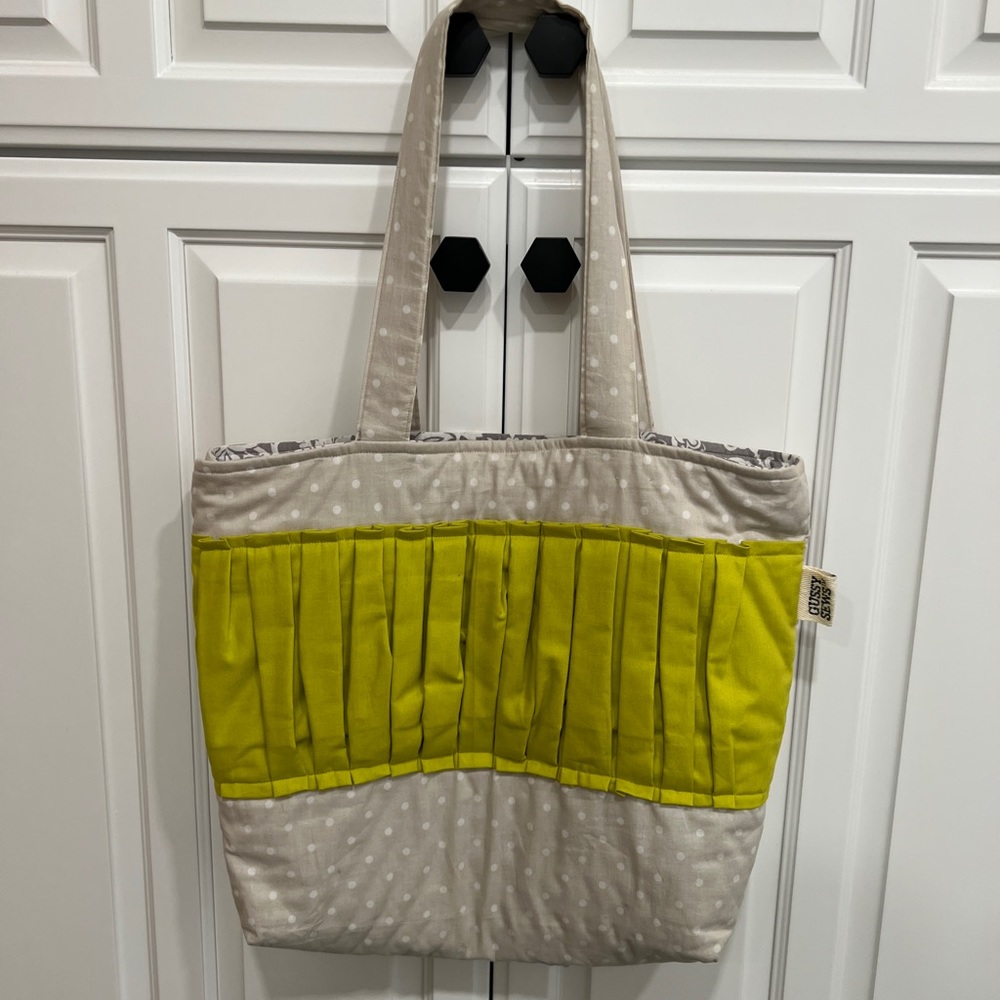 Gray/white polka dot bag with green ruffle